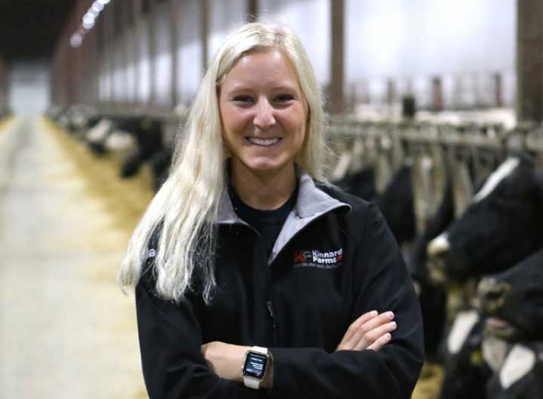 Woman smiling with cows in the background