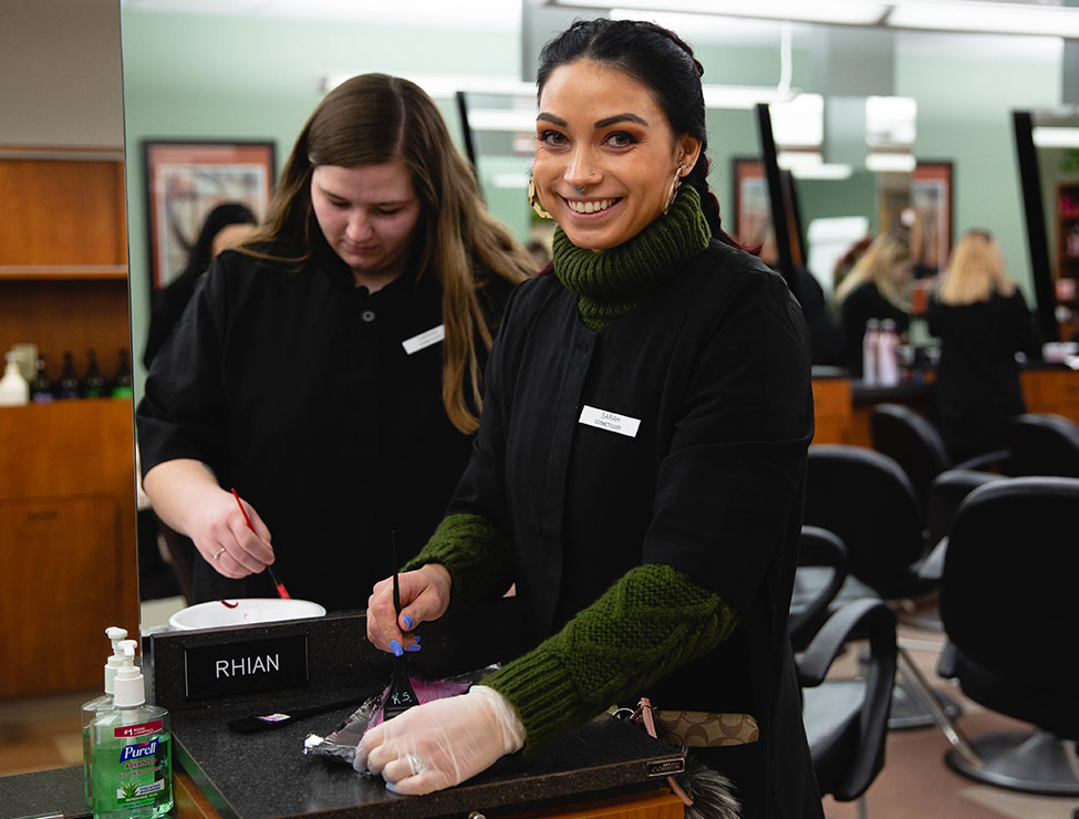 Cosmetologists smiling and mixing hair dye