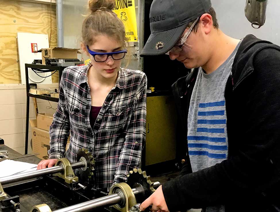 Two students building machine