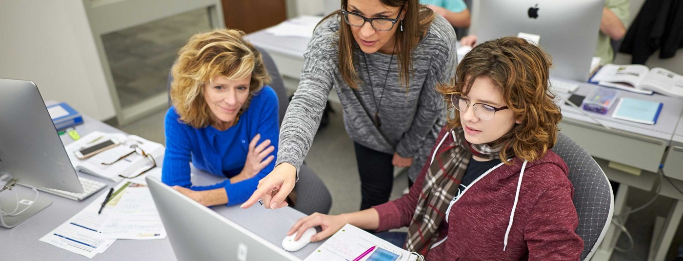 Instructor showing something on computer screen to students