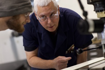 Instructor working closely with student to learn the CNC Machine