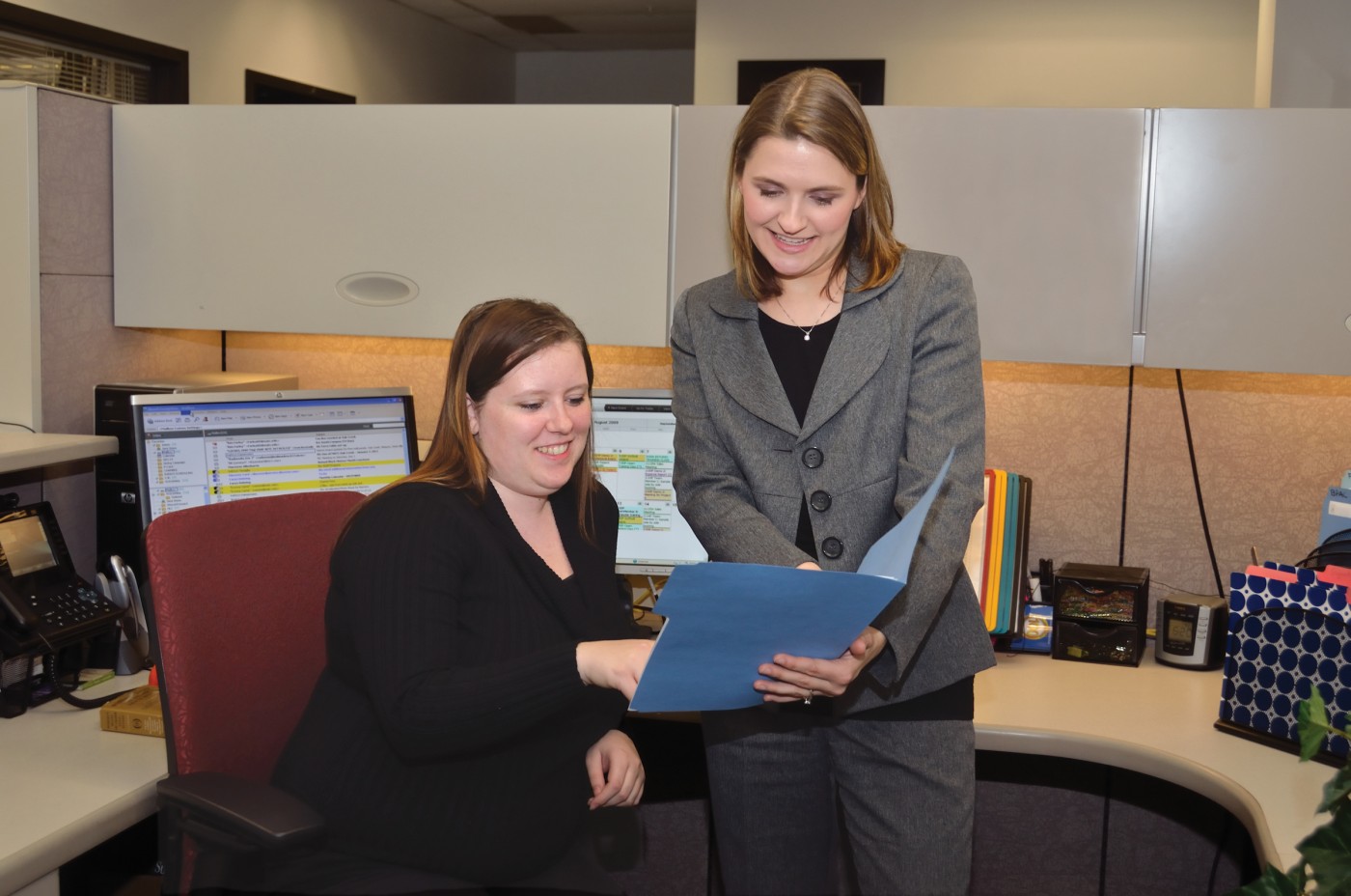 Office Technology Assistant chatting with coworker