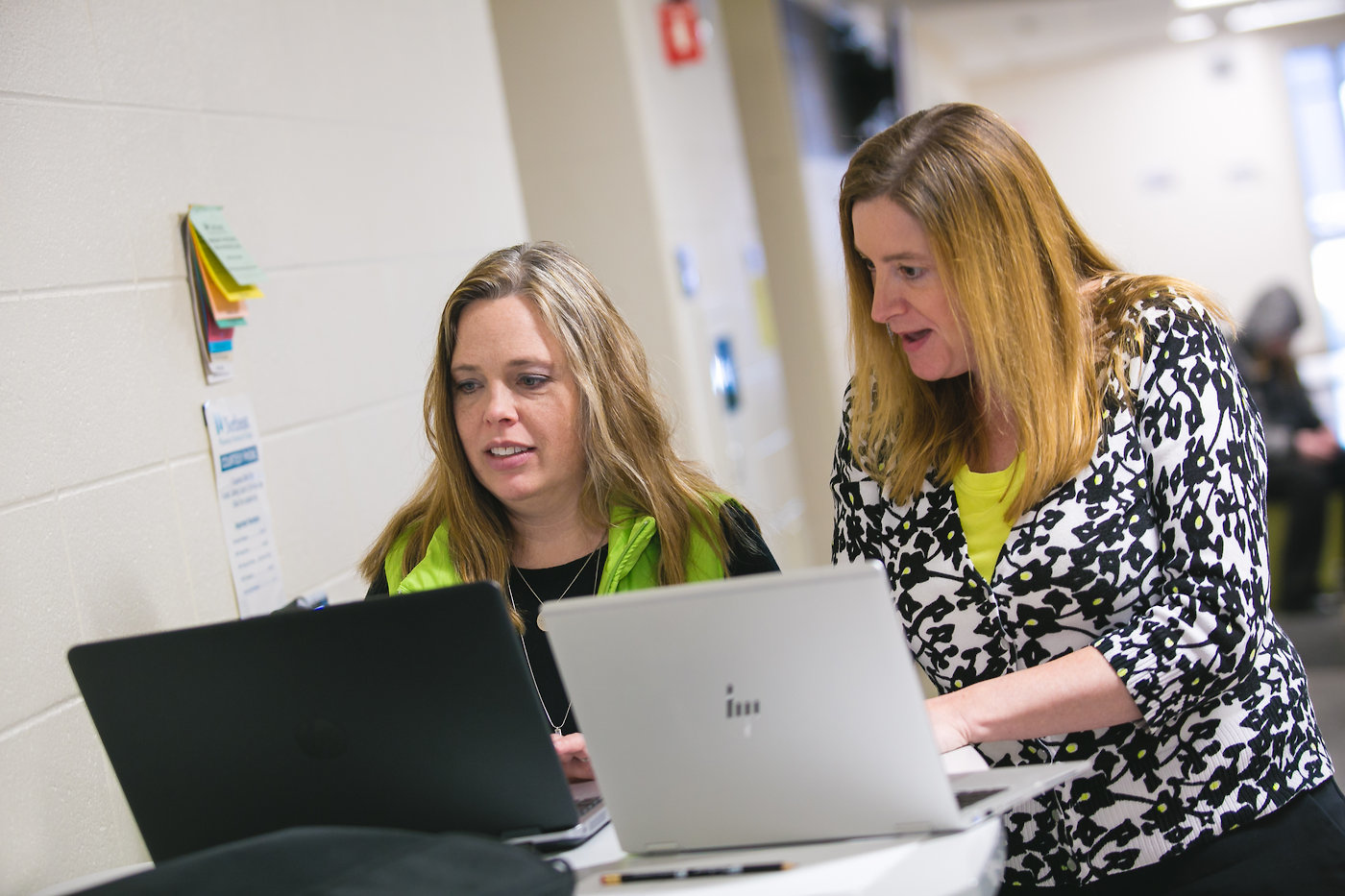 students comparing notes on laptops