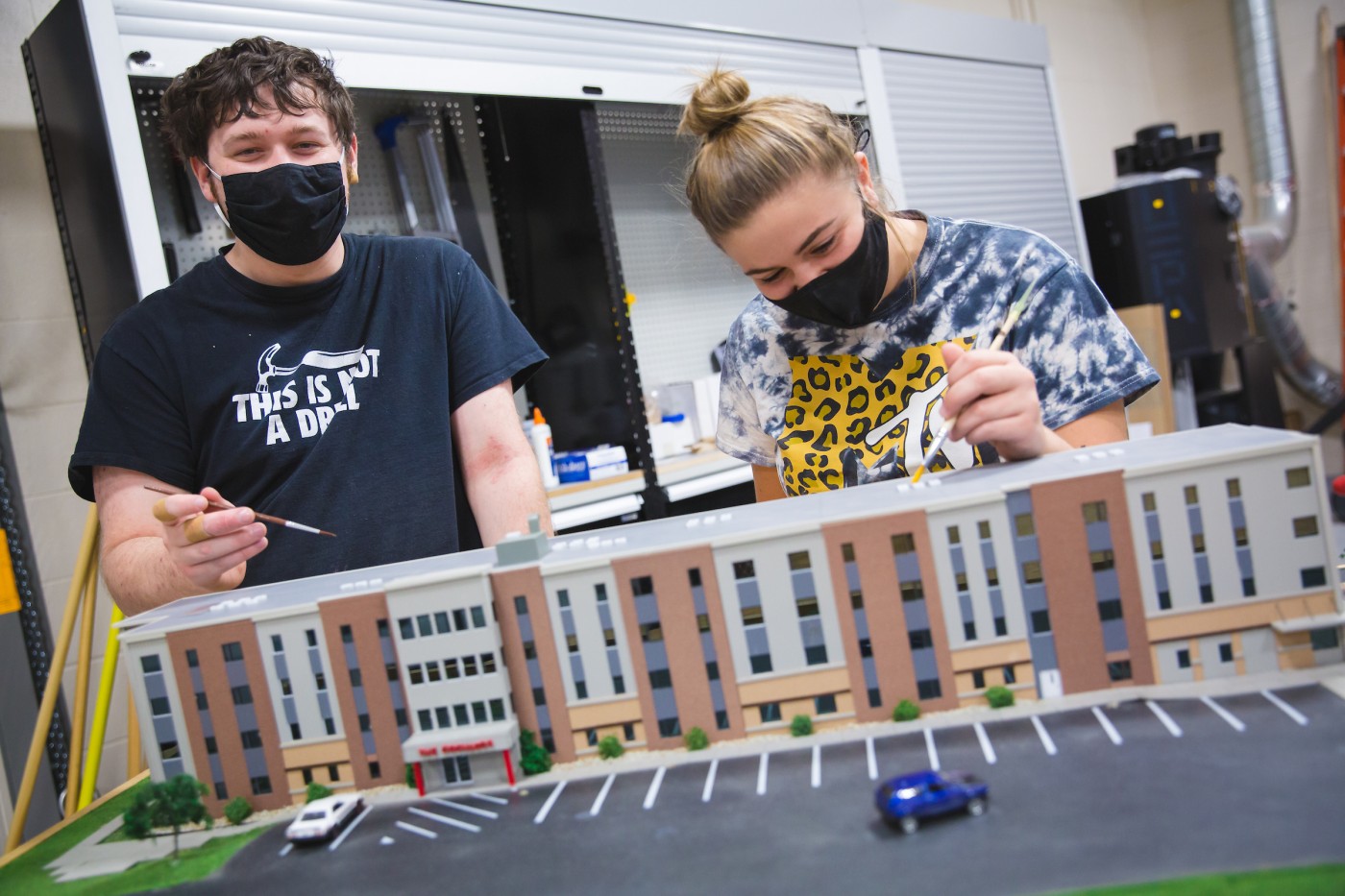 Students painting 3D model while wearing proper PPE