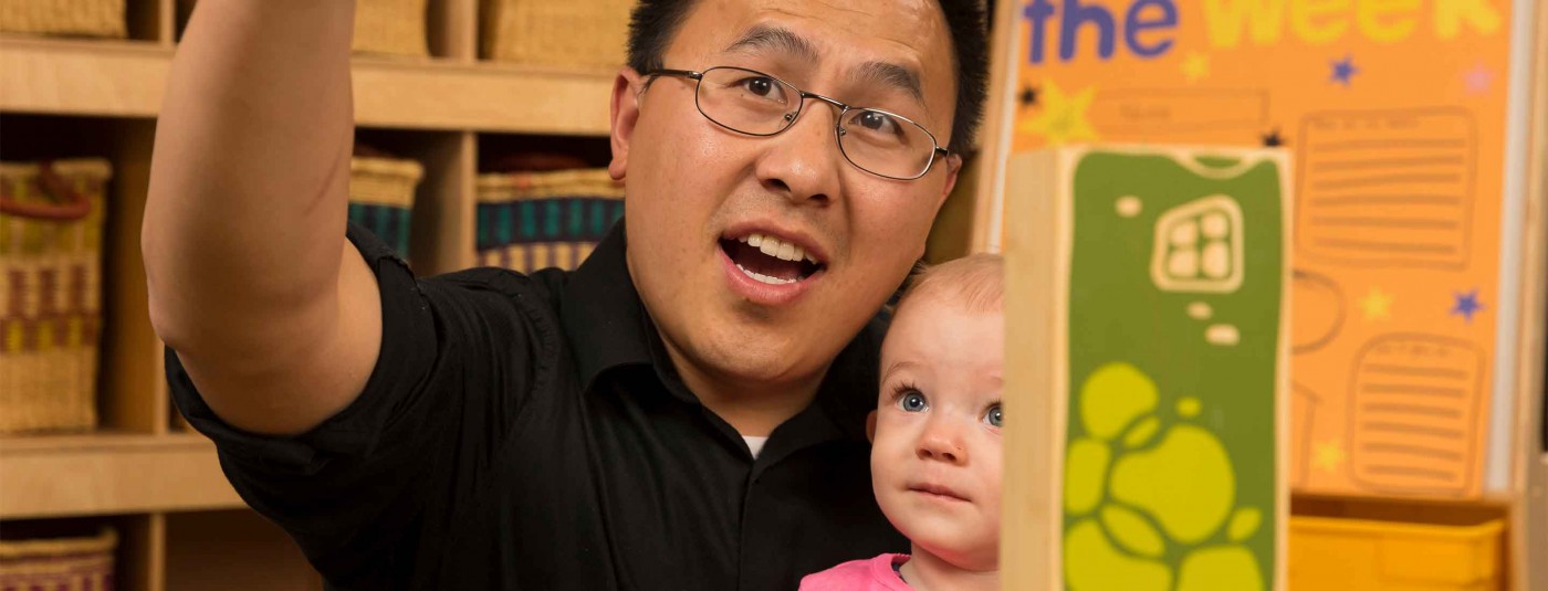 Teacher in classroom with young child