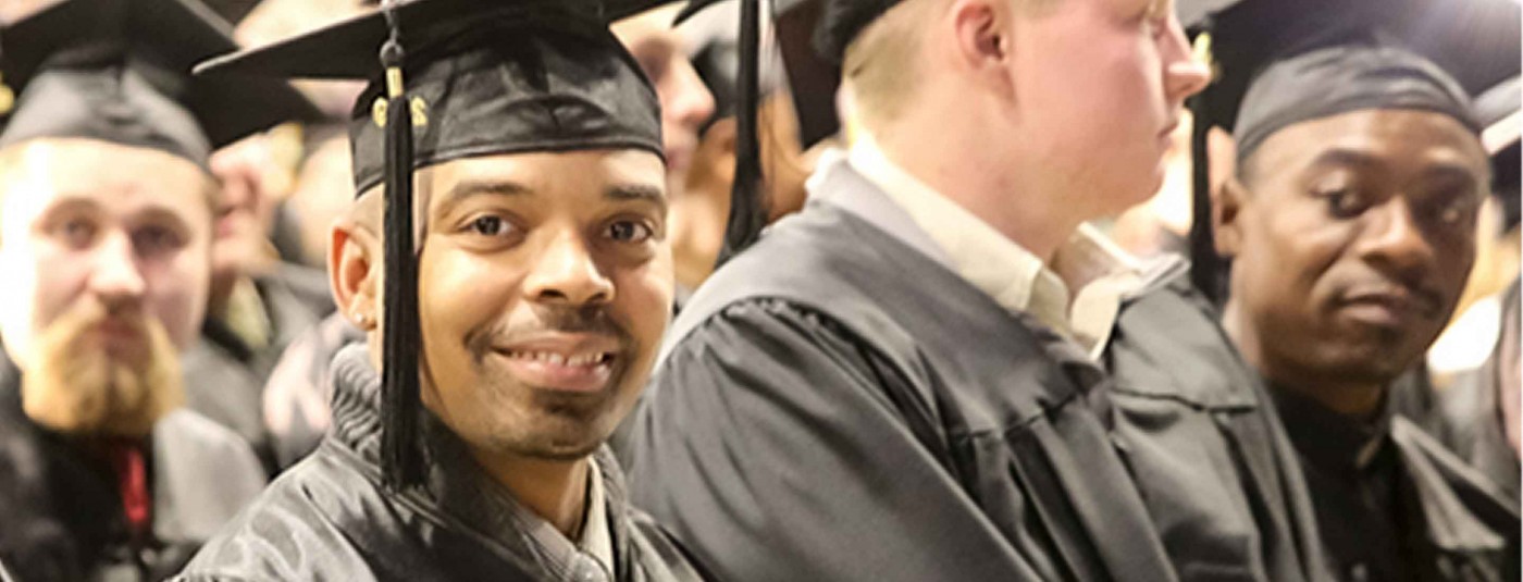 graduate smiling in cap and gown