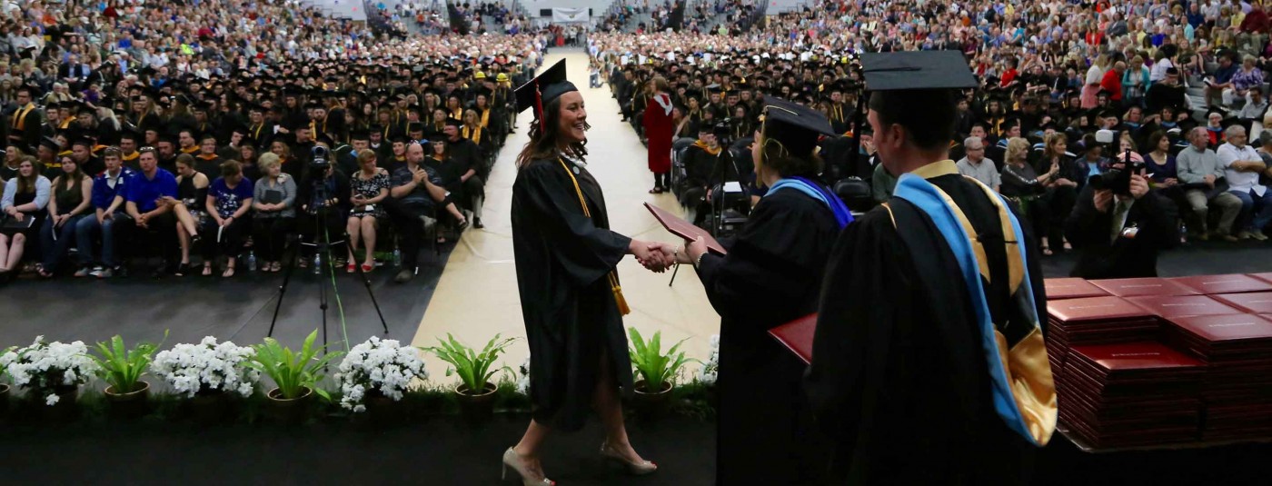 Graduate walking across ceremony stage