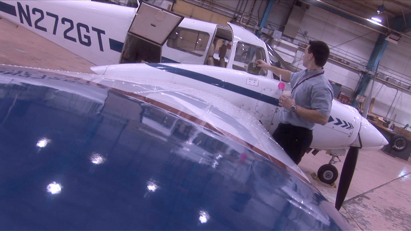 Person standing next to airplane wing