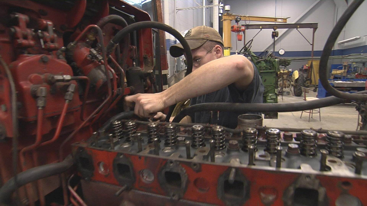 Man repairing tractor