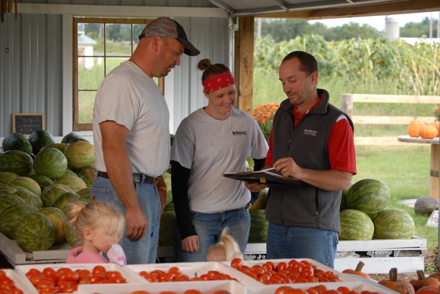 Family standing around farm stand