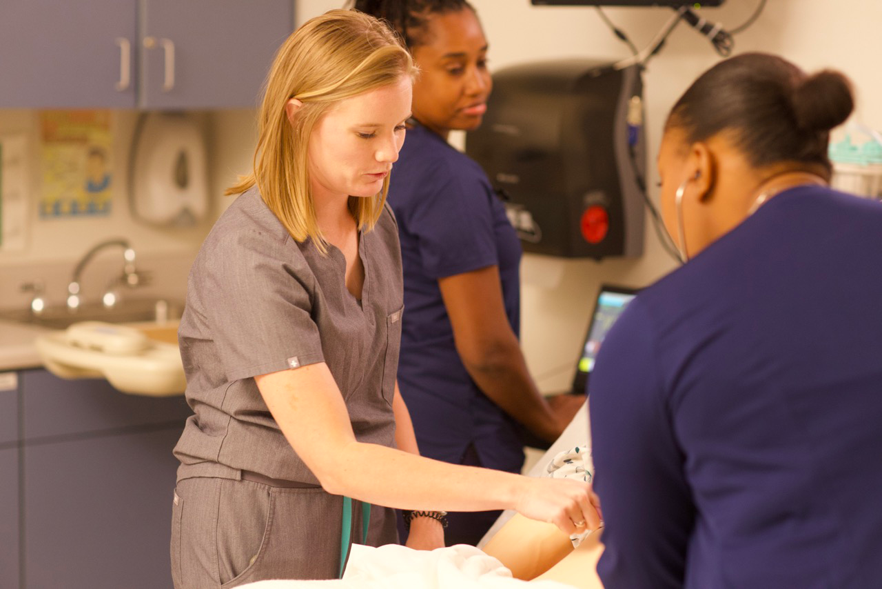 Nurses checking vitals of a simulated patient