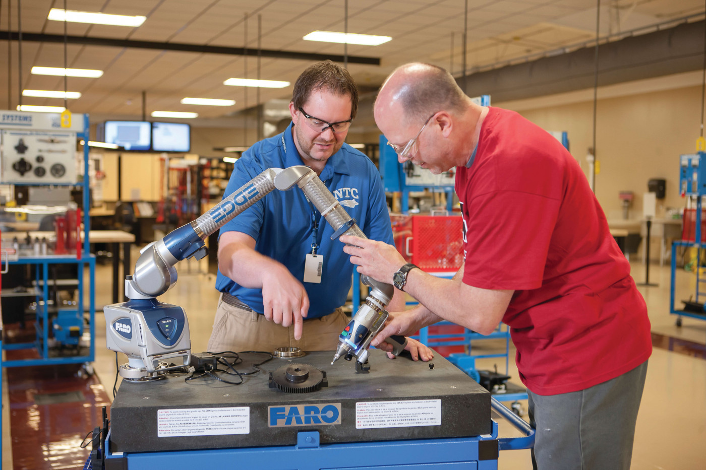 students adjusting a robotic arm